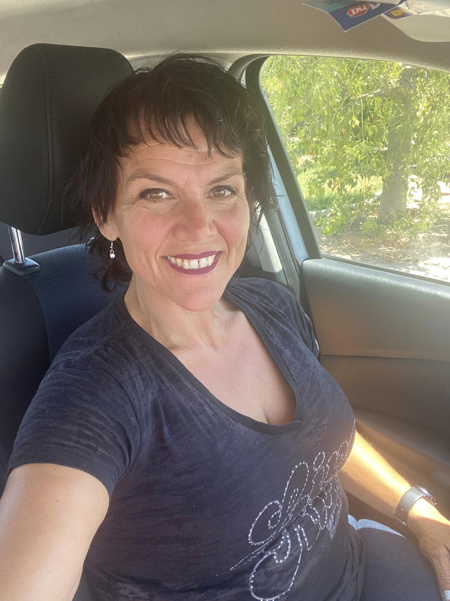 Close-up portrait of Kat smiling in a car after her weight loss.