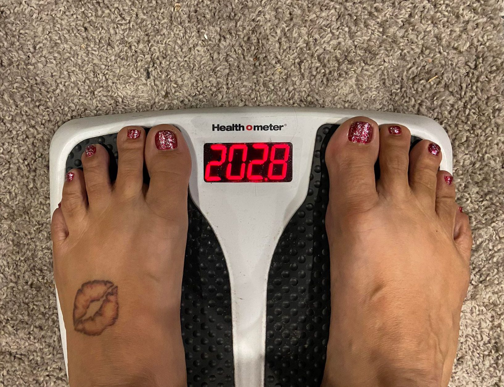 Kat standing on a digital scale showing 202.8 pounds.
