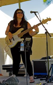 Kat performing onstage with a bass guitar before her weight-loss journey.