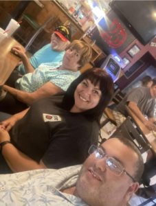 Kat seated with family and friends at a restaurant before her weight-loss journey.