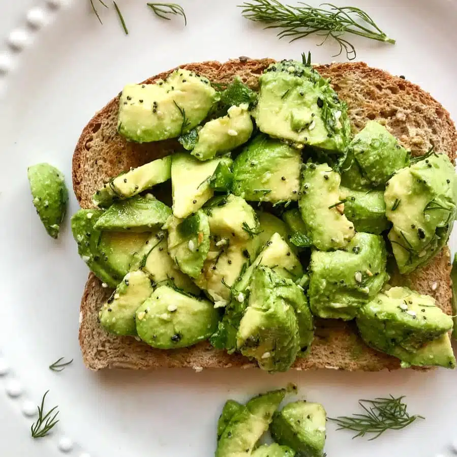 Avocado toast topped with herbs and seasoning.