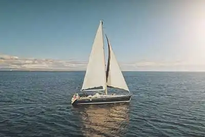 Wellfound Yachts | Aerial view of a sailing yacht with a large white spinnaker sail, racing on the open sea under sunlight Florida, USA2012
