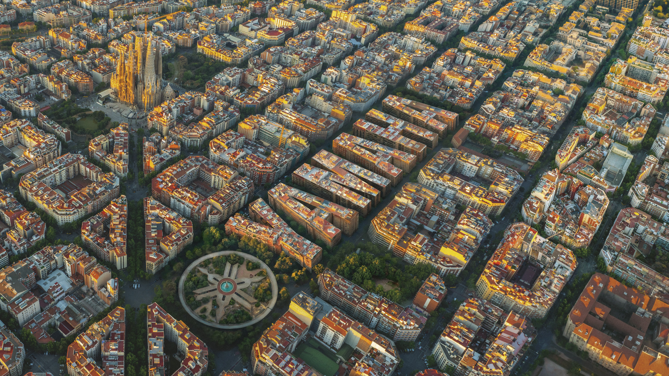Vista aèria de l'Eixample de Barcelona a la posta de sol, amb els edificis formant les lletres de la paraula Yamaha i la Sagrada Família de fons.