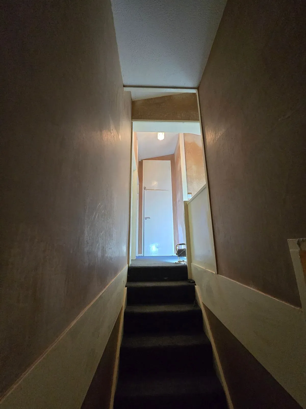Looking up a freshly plastered staircase with smooth multi-finish walls