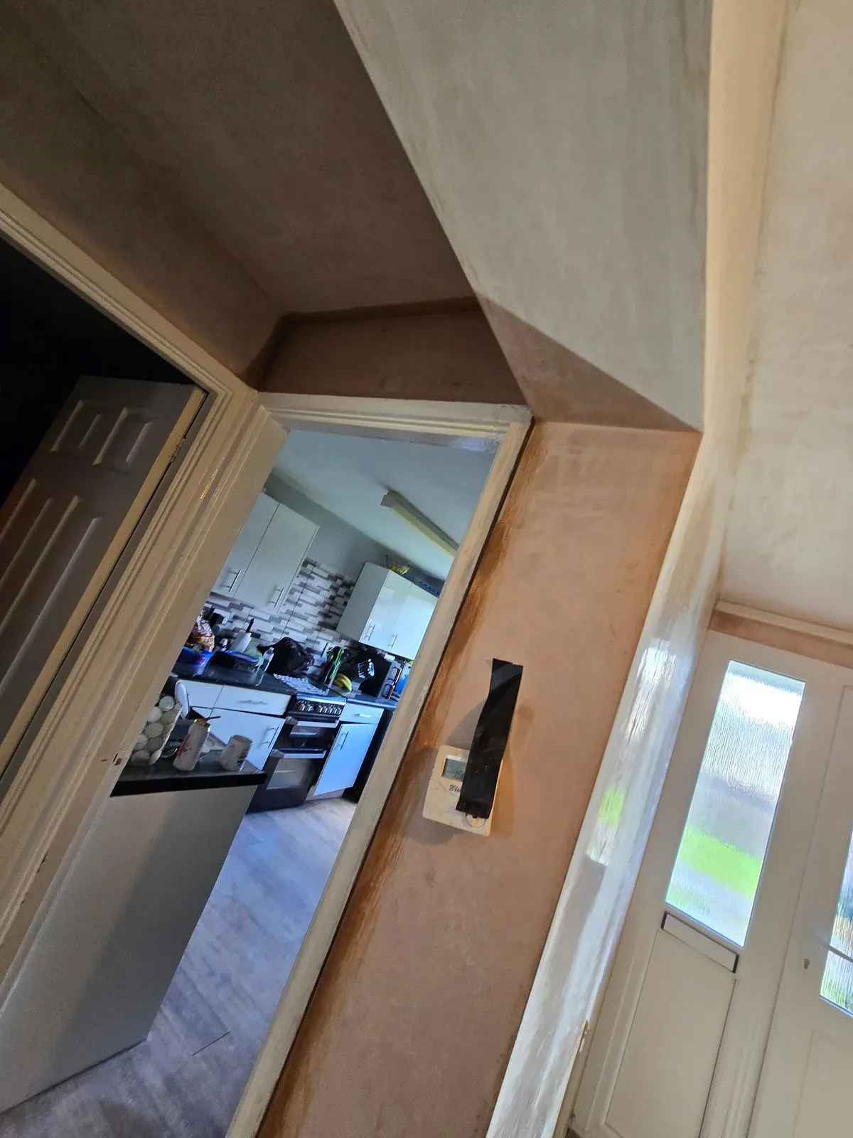 Neat plastering reveals around a kitchen entrance door in a residential renovation