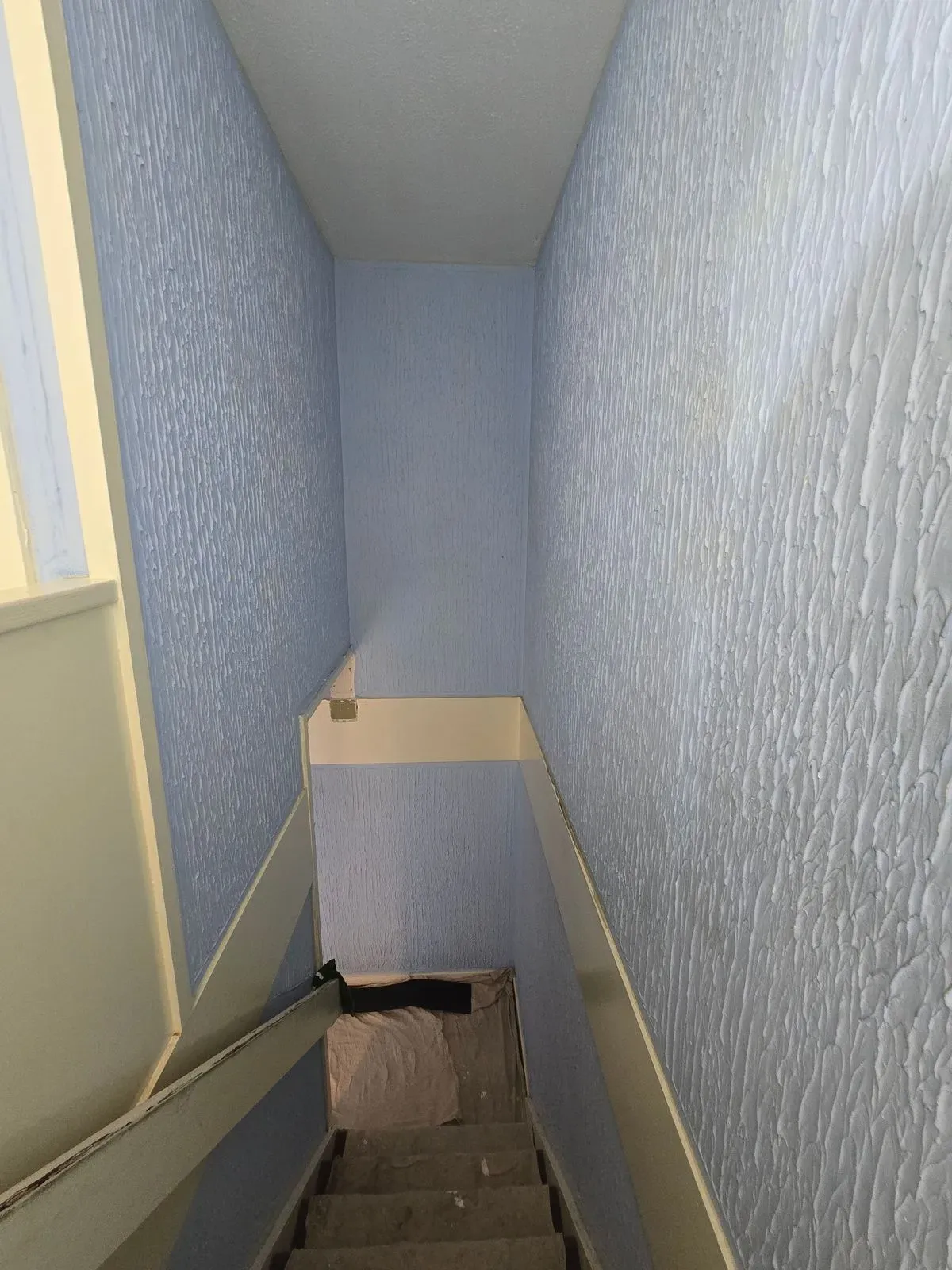 Old patterned Artex on staircase walls before scraping and two-coat plastering