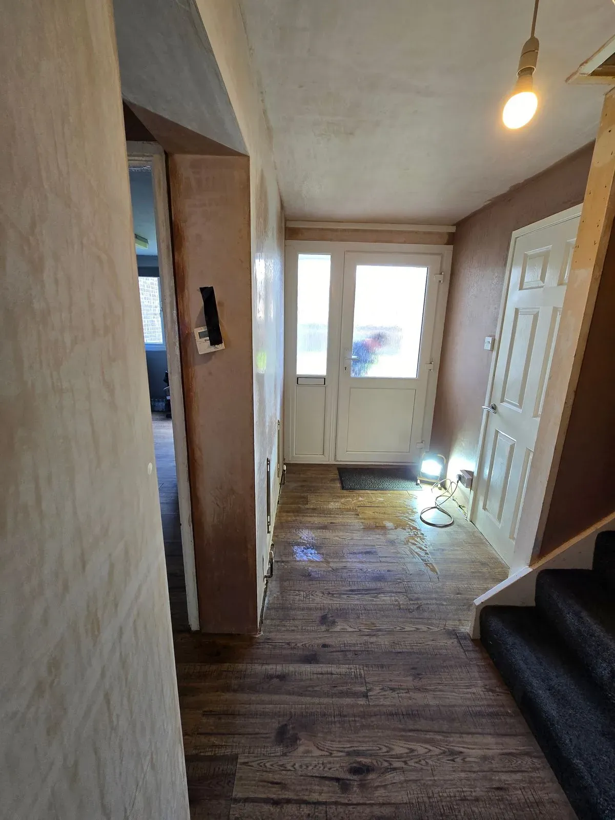 Bright entrance hallway with newly plastered walls and ceiling after Artex flattened