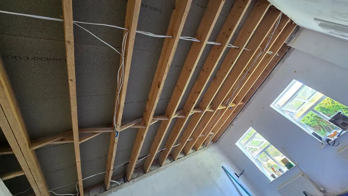 Clearing a leak-damaged ceiling in Weston-super-Mare. Old plasterboard and coving removed to assess structural joists.