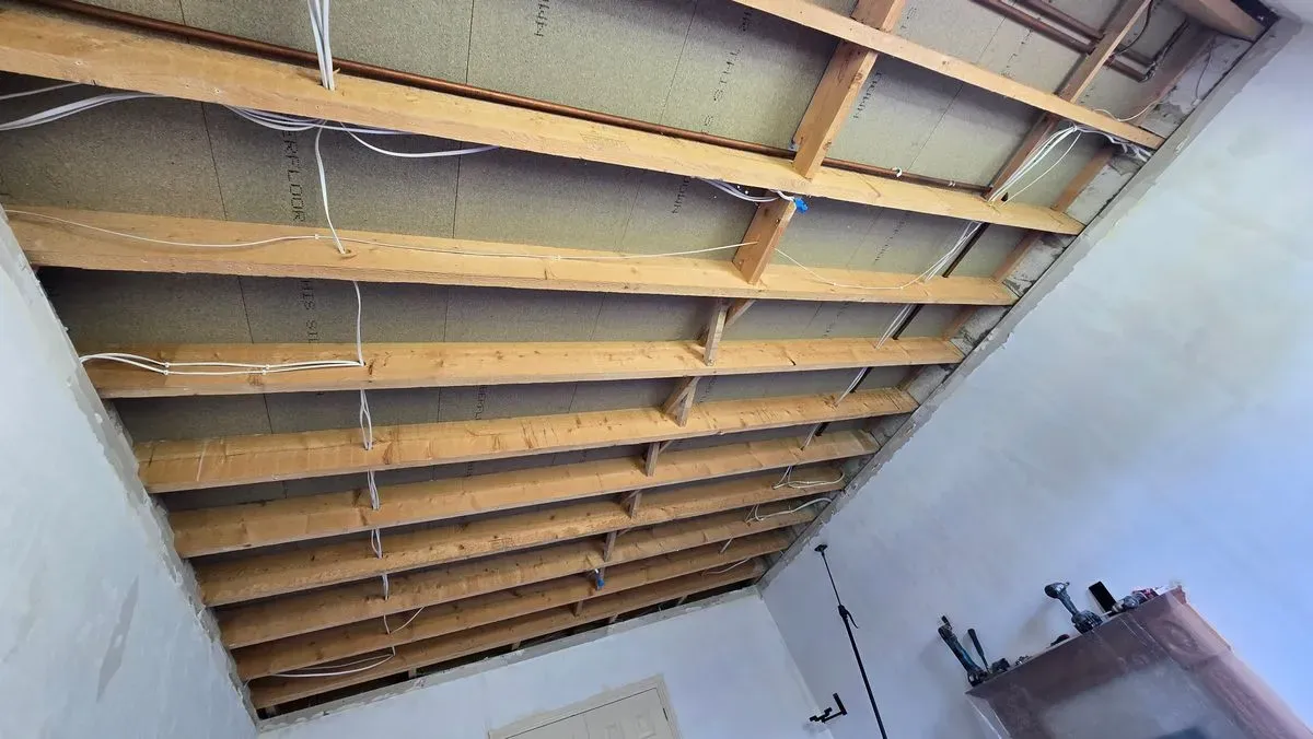 Professional ceiling removal in Lympsham (BS24) following water damage. Exposed joists ready for new plasterboard installation.