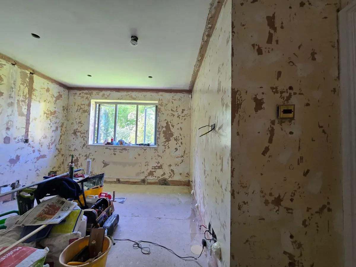 Installing galvanized angle beads and applying PVA primer to walls in a Westbury-on-Trym home renovation.