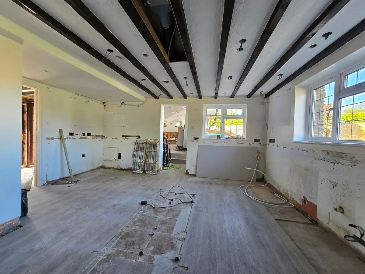 Kitchen plastering preparation in Rangeworthy applied yellow grit and metal angle beads around windows Bristol showing ceiling beams and stripped walls