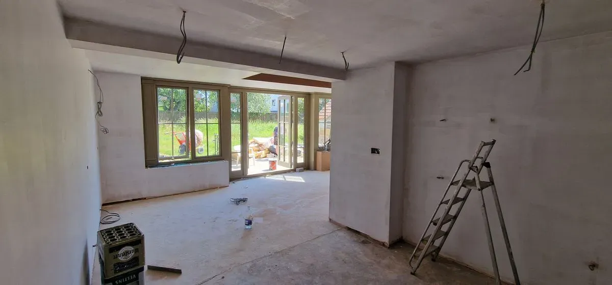 Professional plastering prep in Almondsbury: applying blue grit, window beads, and scrim tape to walls and joins.