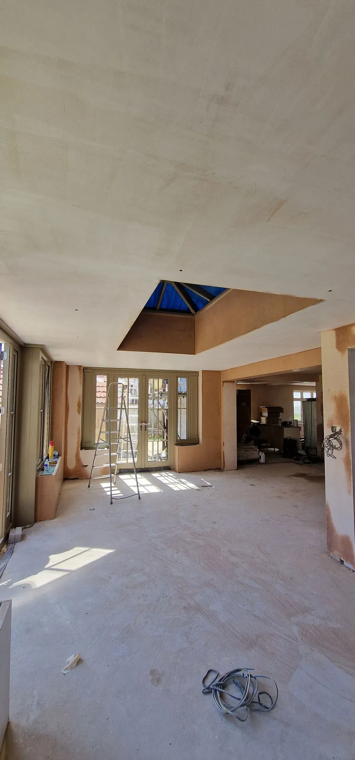 Professional plastering prep in Almondsbury: applying blue grit, window beads, and scrim tape to walls and joins.