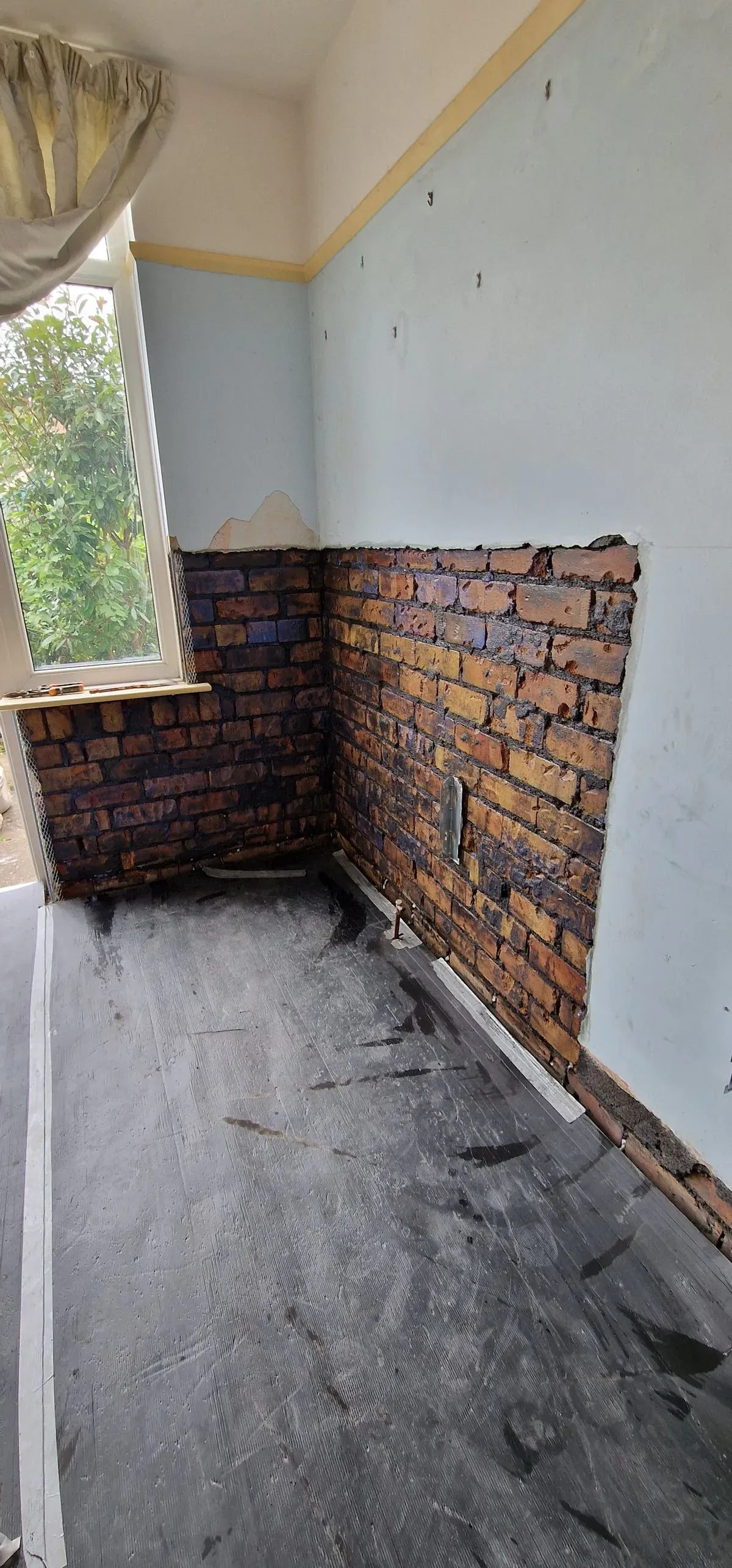 alt="local job in Filton Bristol damp wet render removed and a new DPC cream damp course installed at floor level"