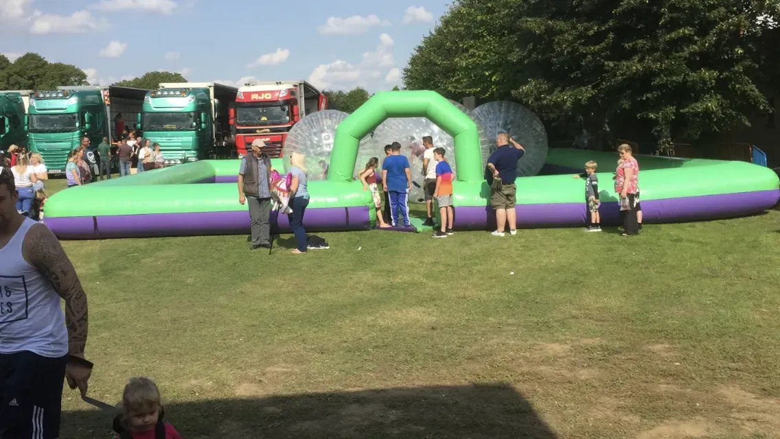 Group of friends celebrating at a fairground with inflatables
