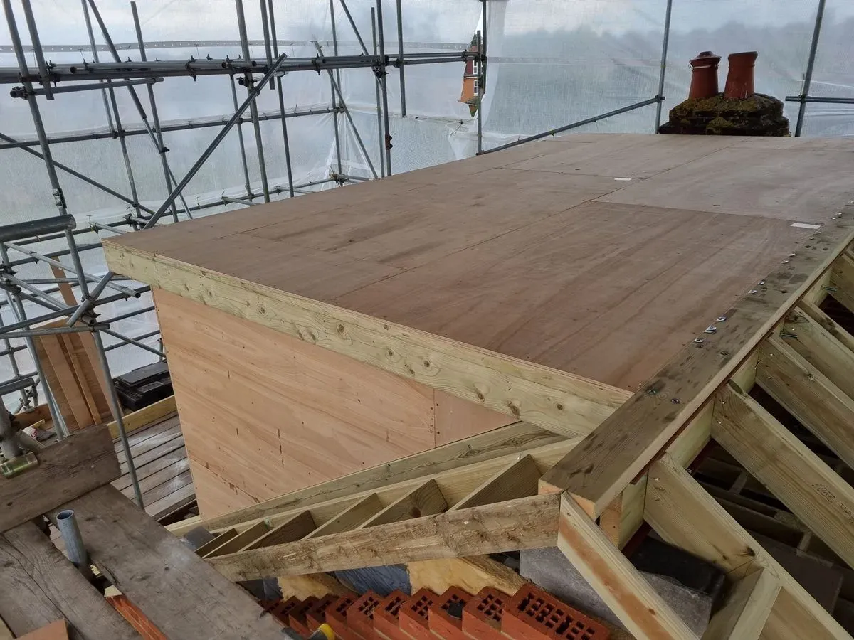 Professional builders discussing plans at a Hedge End construction site.
