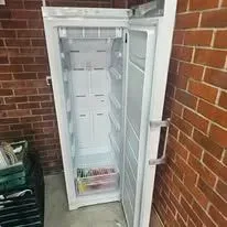 Local technician installing repaired fridge freezer