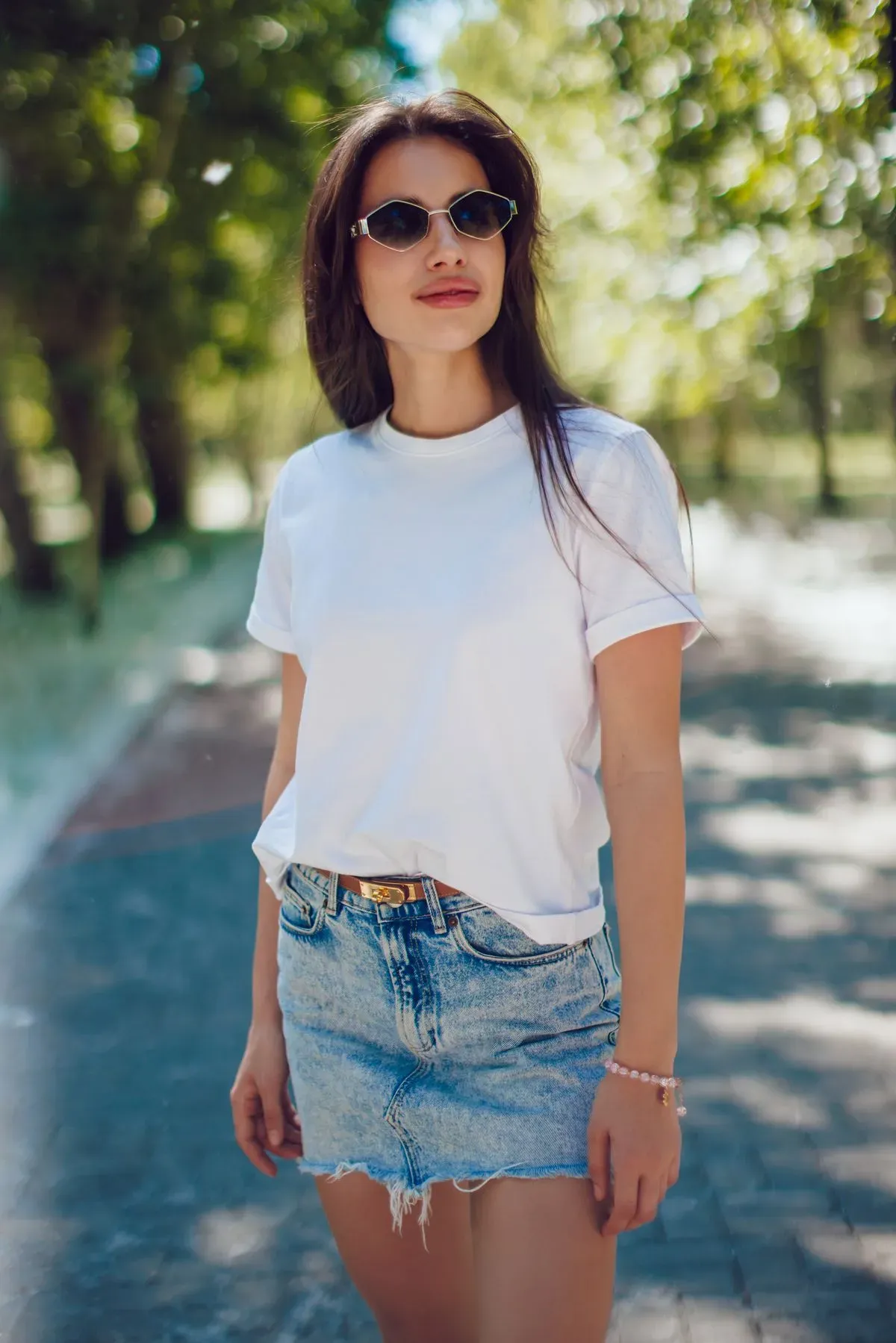 happy-young-woman-white-tshirt-denim-skirt-walking-park collection background image