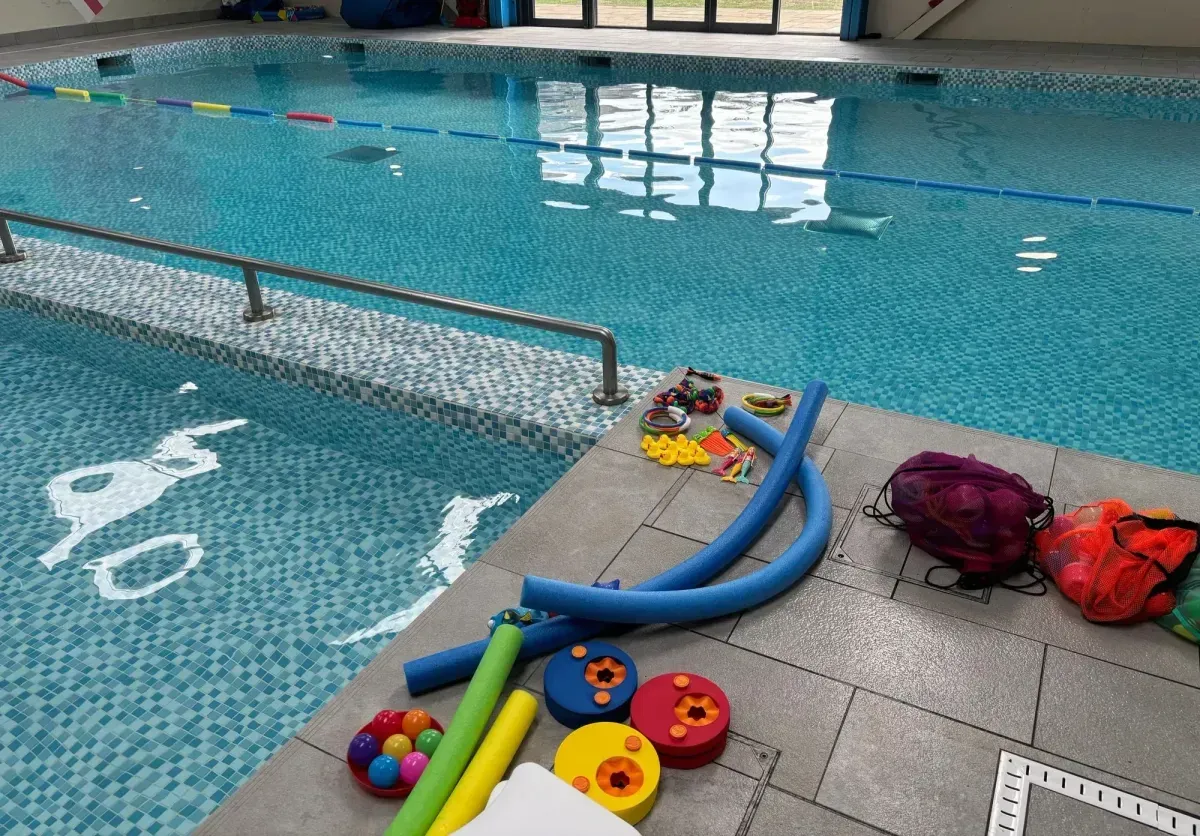 beginner swimming class in new romley with a smiling instructor