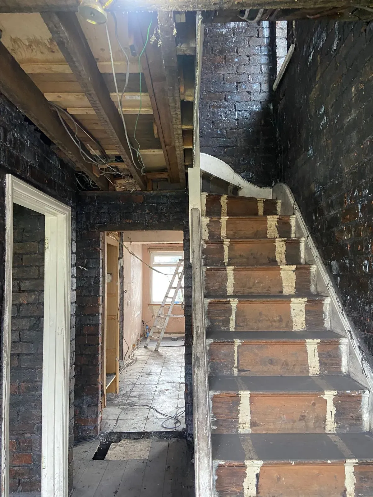 Full house renovation in Swansea during strip out phase showing staircase and internal walls being prepared