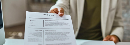 Person handing over a document titled RESUME