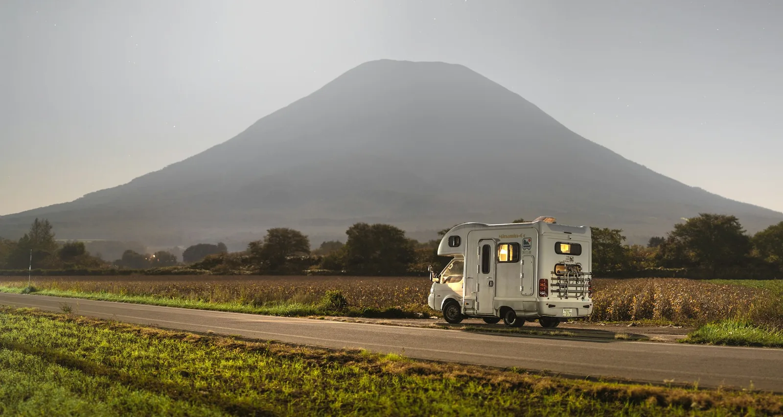 A camper on a mountain road at sunset