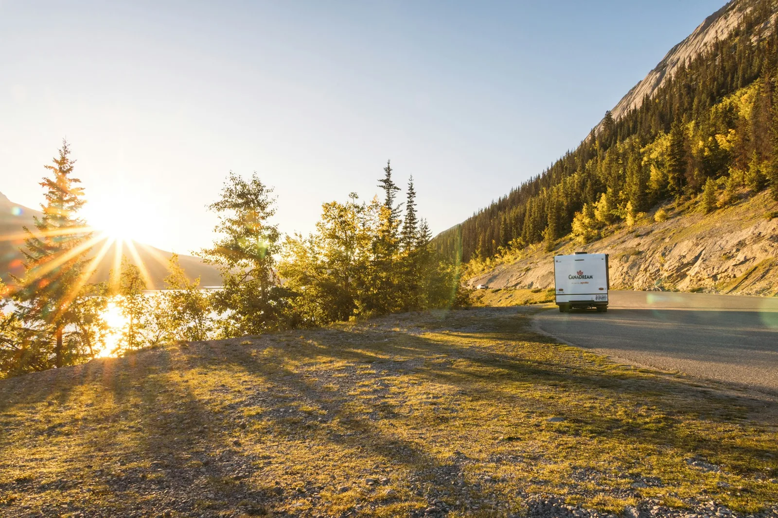 A camper on a mountain road at sunset
