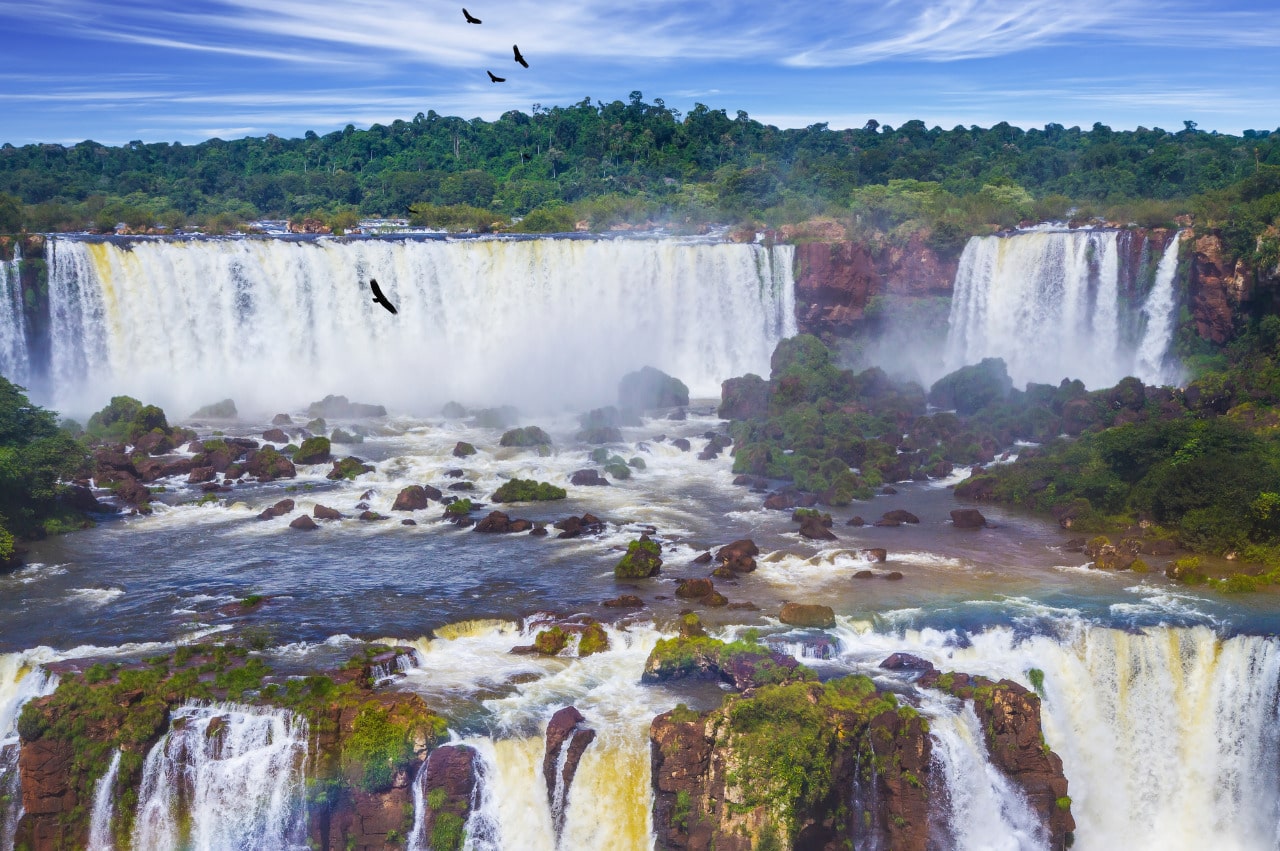 Birds take flight over Iguazu Falls that border Brazil and Argentina