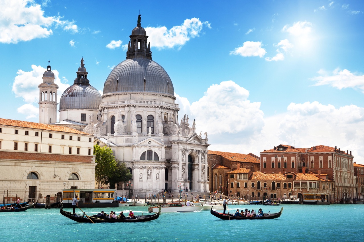 Gondolas on the Grand Canal passing the Santa Maria della Salute in Venice, Italy.