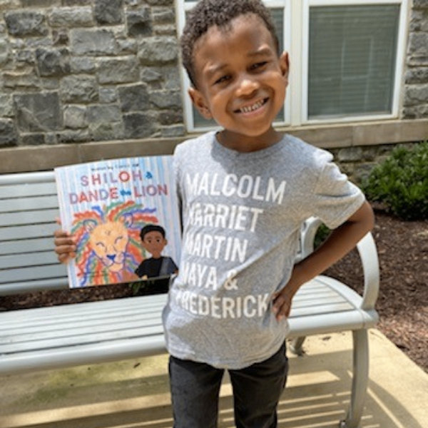 Boy in gray shirt standing by bench