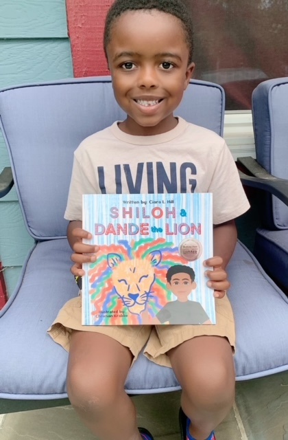 Boy in tan shirt holding book