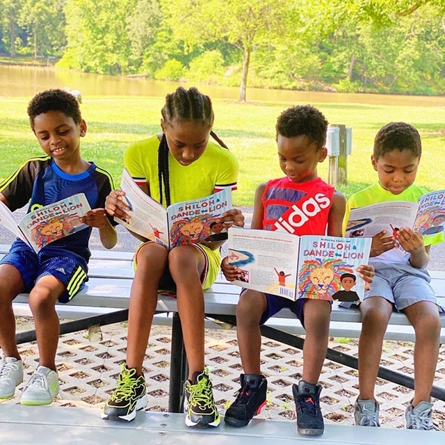 4 kids reading Shiloh outside