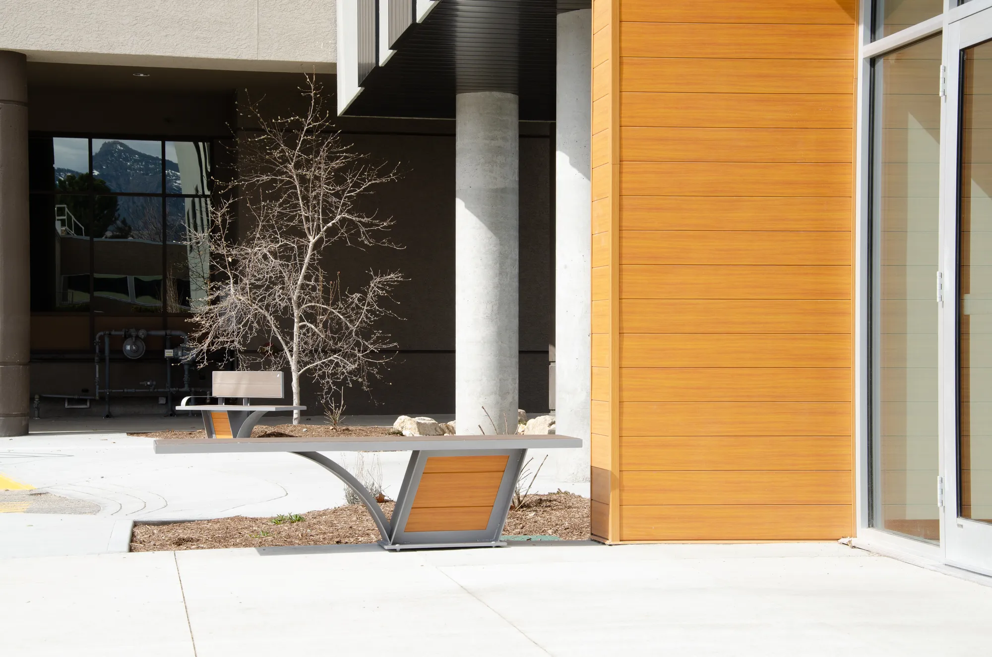 City Scape bench provides a modern seating solution for outdoor spaces. The bench features a sleek design with a combination of metal and recycled plastic lumber.