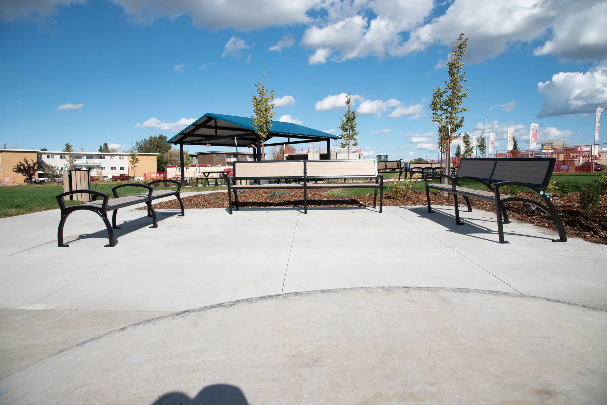 These benches offer comfortable seating in a park setting. The benches feature recycled plastic lumber and a durable powder-coated metal frame.