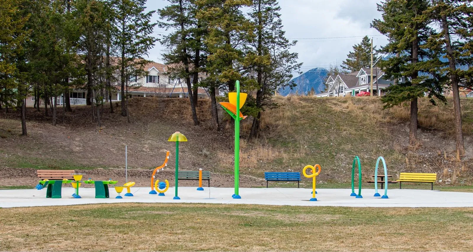 Standard benches provide seating at Radium Splash Park in Radium Hot Springs, British Columbia. The park features colorful play structures and mountain views.