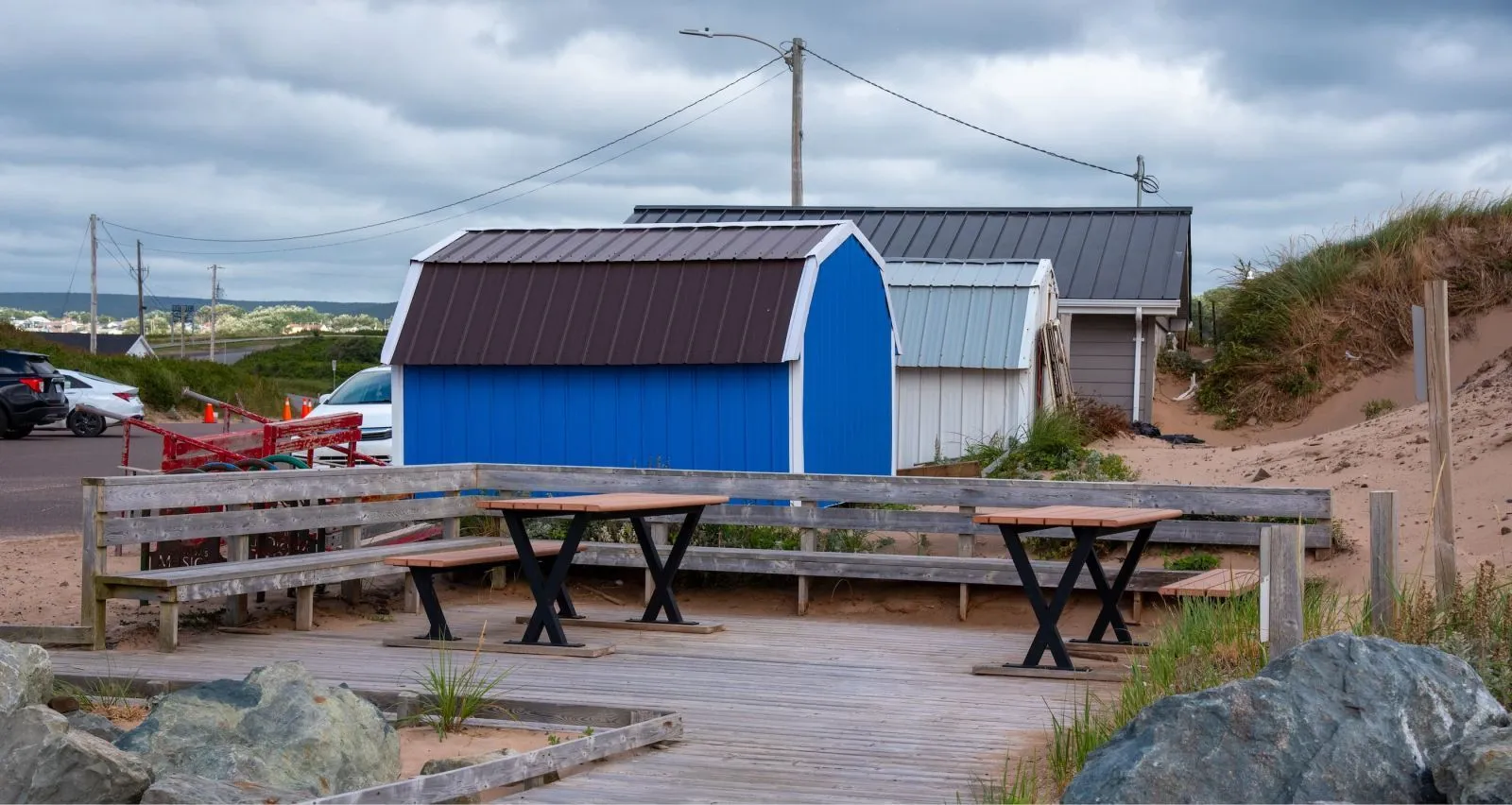 Bayview picnic tables offer a place to relax and enjoy the beach at Inverness, Nova Scotia. The tables feature a wooden top and black metal frames.