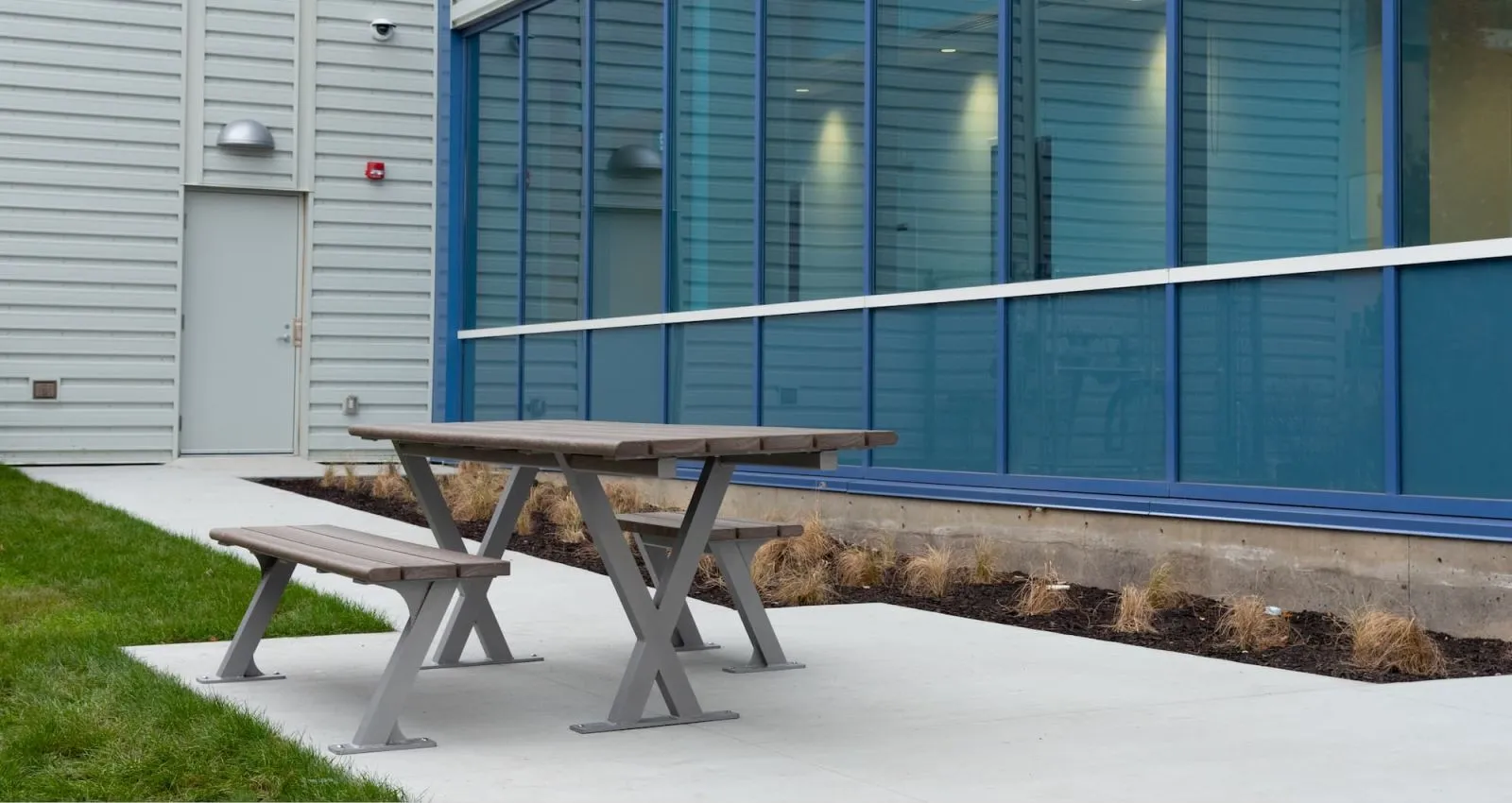 Wheelchair accessible picnic table provides an inclusive outdoor dining space. The table features recycled plastic lumber and a powder-coated metal frame.