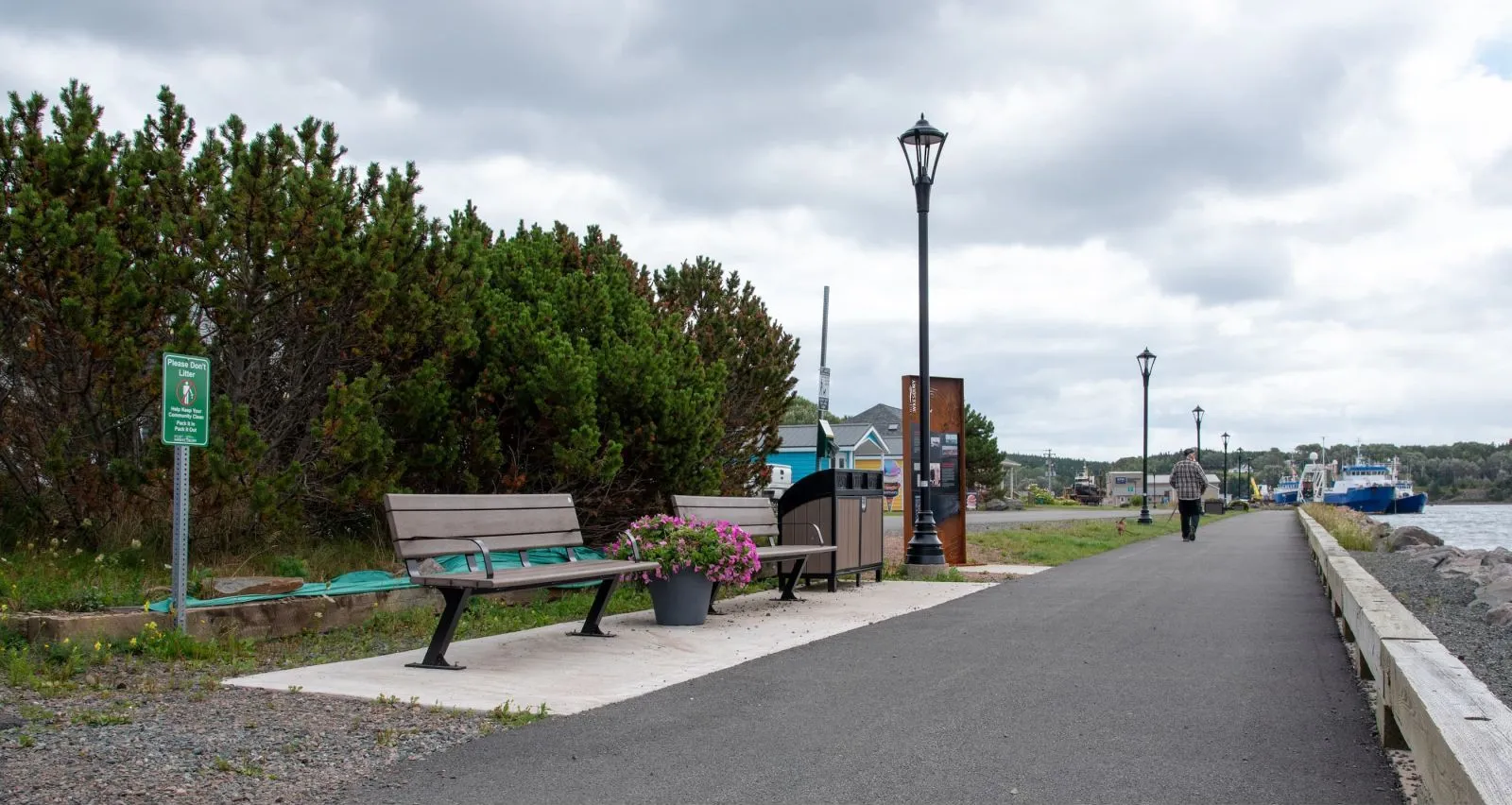 Bayview benches and a Modena 2 Stream Recycling Station provide seating and recycling options along a waterfront path. The benches feature recycled plastic lumber and powder-coated metal frames.