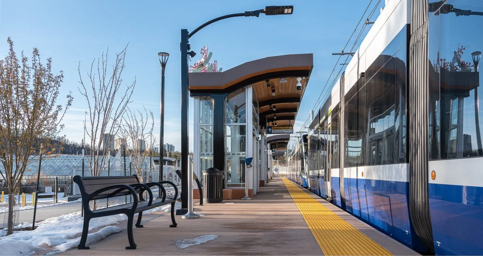 A Mountain Classic bench sits on the platform of the Edmonton LRT Valley Line, providing seating for transit users. The bench features recycled plastic lumber and a durable powder-coated metal frame.