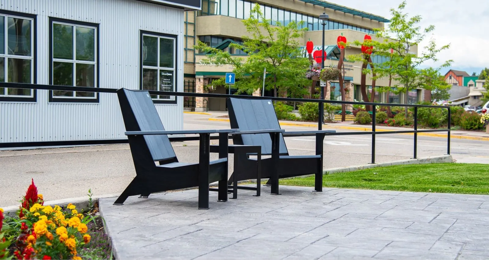 Two JEM Lounge Chairs and a Side Table create a relaxing outdoor seating area. The black recycled plastic lumber and powder-coated frames offer a modern aesthetic.