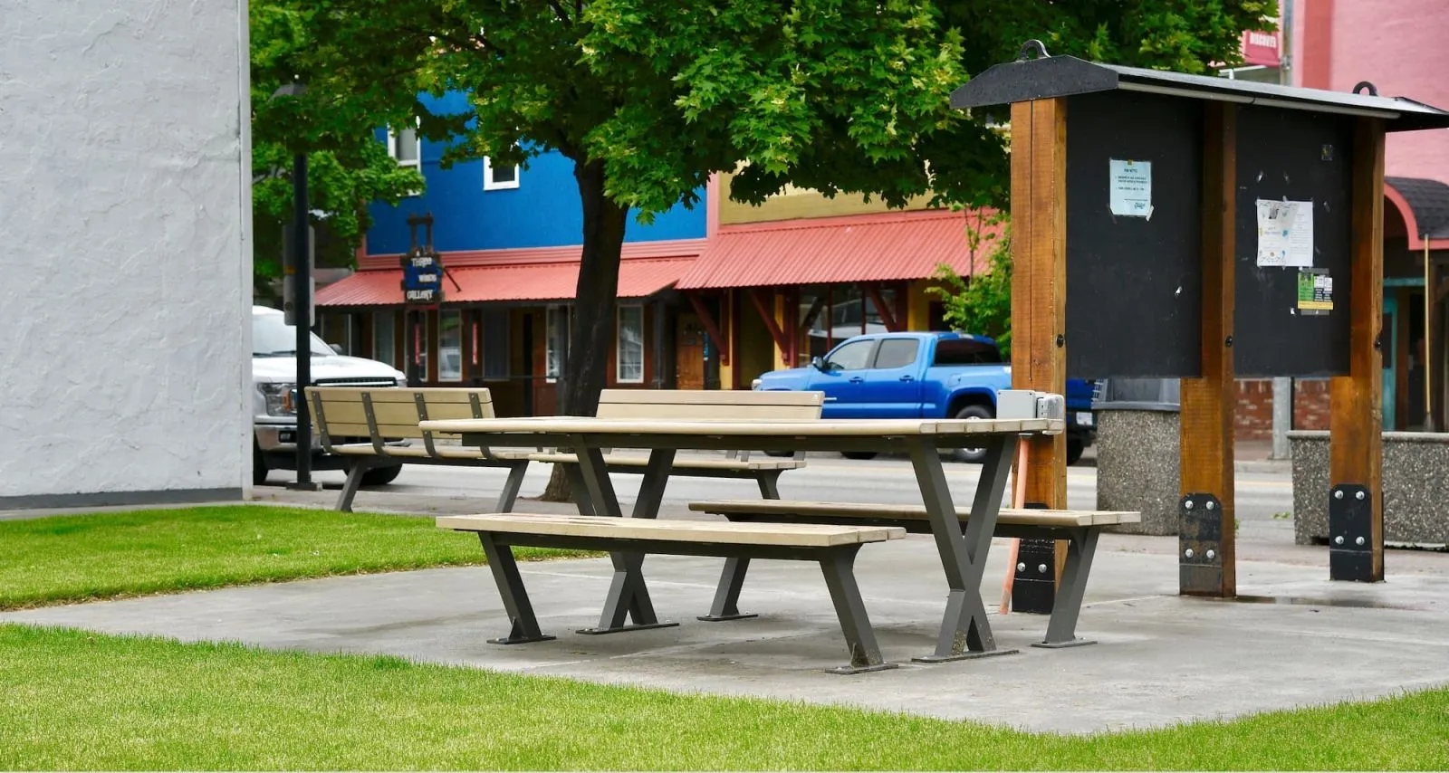 Wheelchair accessible picnic table provides an inclusive outdoor dining space in a downtown setting. The table features recycled plastic lumber and a durable metal frame.