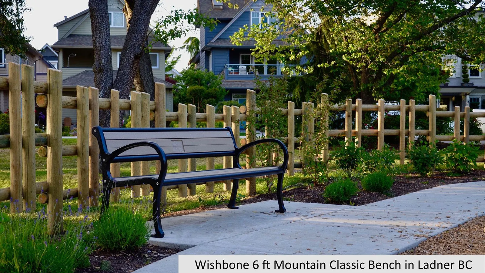A 6-foot Mountain Classic bench provides seating along a paved path in Ladner, British Columbia. The bench features recycled plastic lumber slats and a black powder-coated frame.