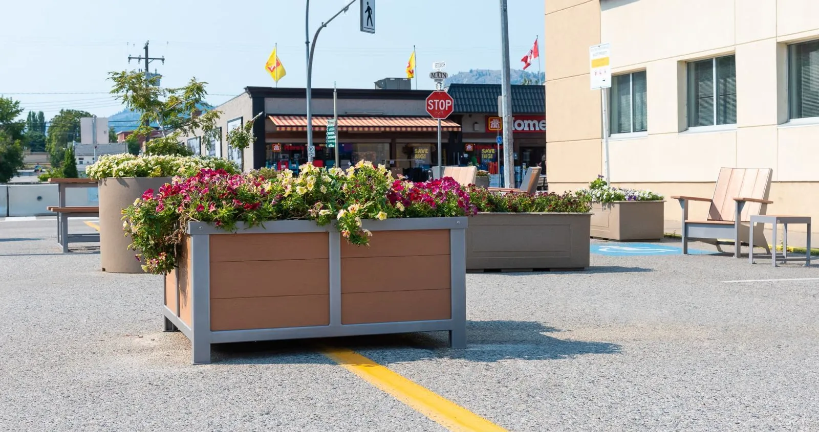 Outdoor planters and seating enhance a commercial area. The planters feature recycled plastic lumber and powder-coated metal frames, adding greenery and visual interest to the space.