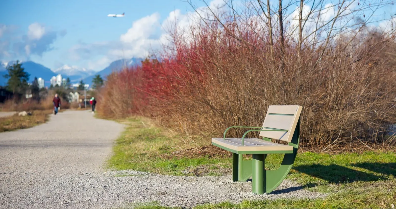 SurRe bench with a back rests along a gravel path. This bench provides a place to rest and enjoy the outdoors.