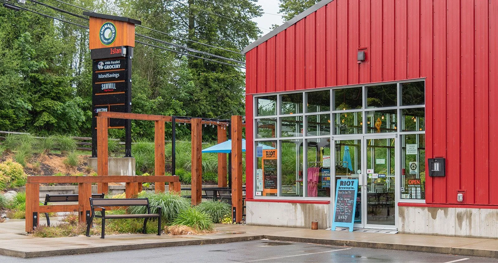 A Beselt bench provides seating outside a commercial building in Chemainus, British Columbia. The bench features recycled plastic lumber and a powder-coated metal frame.