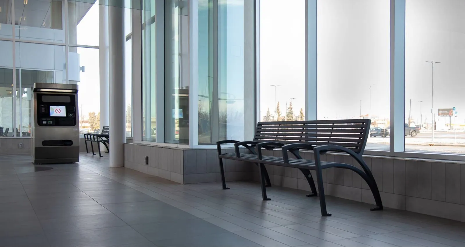 Modena benches provide seating inside the Davies Station of the Edmonton LRT Valley Line. These aluminum benches offer a sleek and modern design for public spaces.