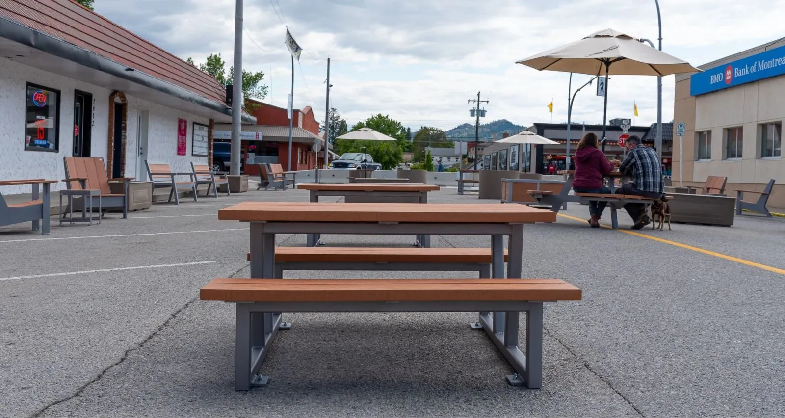 Outdoor picnic tables and benches create a welcoming space for people to gather and enjoy the surroundings. The site furniture is made with recycled plastic lumber and powder-coated metal frames.