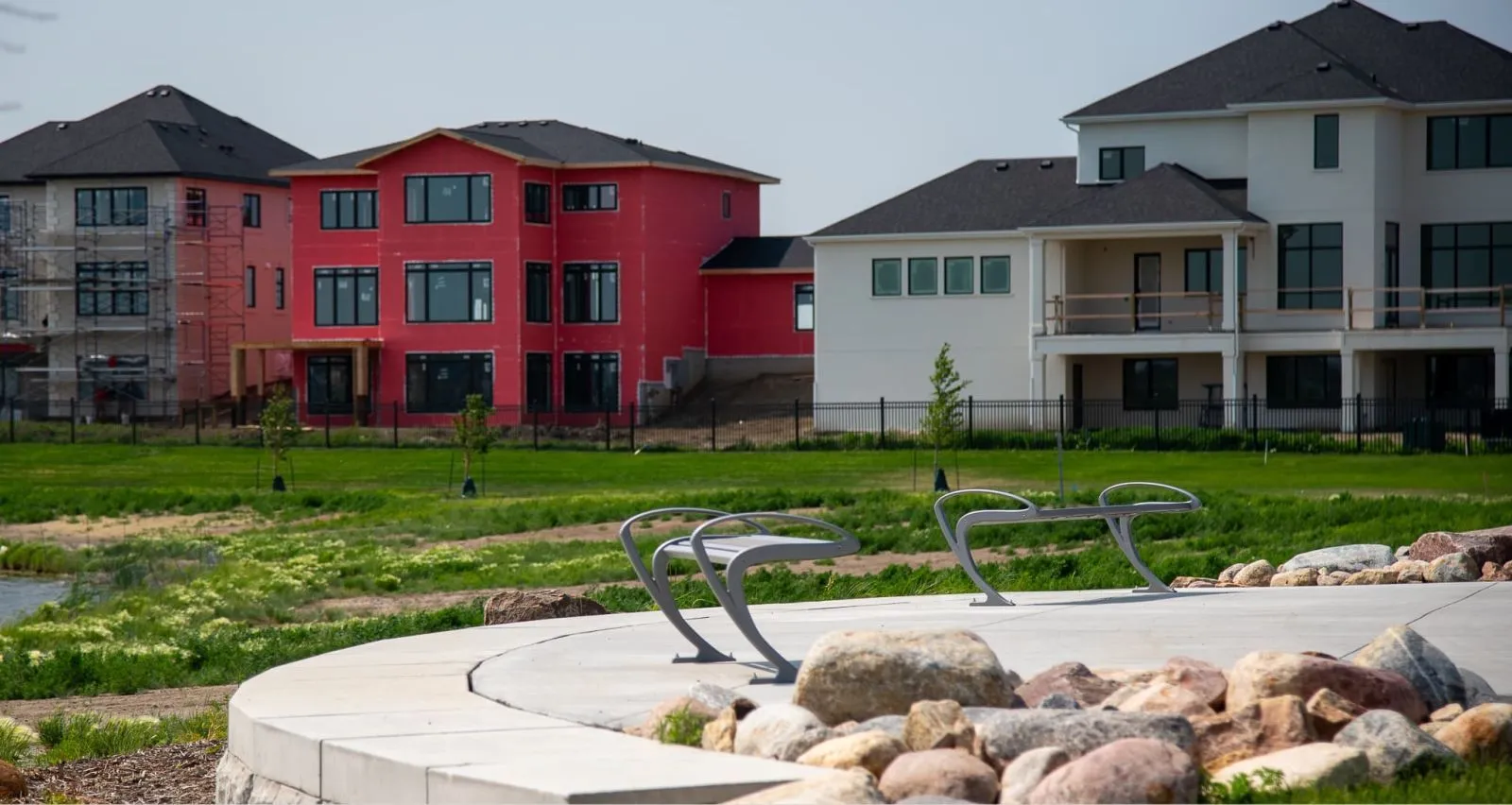These backless benches provide seating in a community space with new homes under construction. The benches offer a place to relax and enjoy the outdoors.