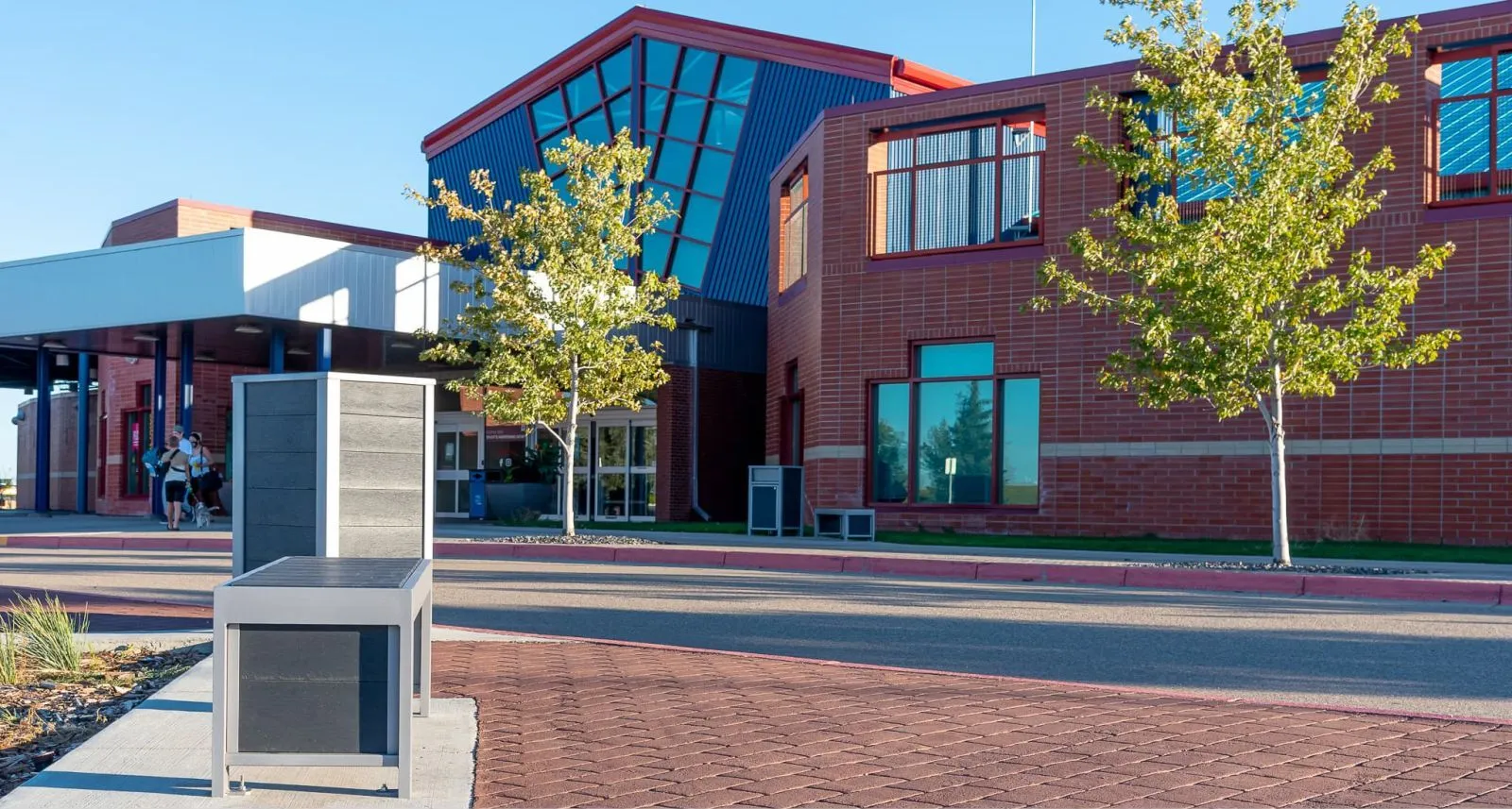 Urban Form backless benches and waste receptacles provide seating and waste disposal at the Family Leisure Centre in Medicine Hat, Alberta. The site furniture complements the modern architecture of the building.