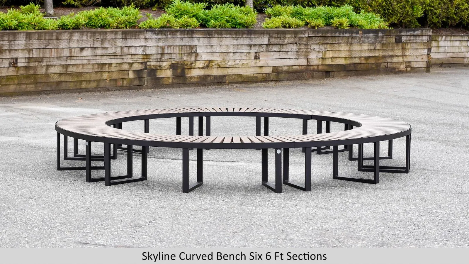Circular bench composed of six curved sections provides ample seating in a park or public space. The bench features recycled plastic lumber slats and a durable powder-coated metal frame.